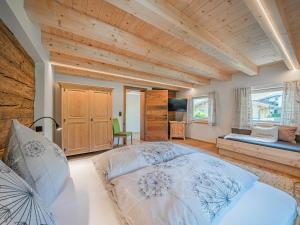 ein Schlafzimmer mit einem großen Bett und einer Holzdecke in der Unterkunft Penningberg Top 1 in Hopfgarten im Brixental