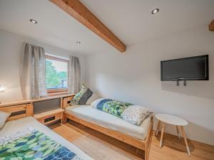 ein Wohnzimmer mit einem Sofa und einem Flachbild-TV in der Unterkunft Penningberg Top 1 in Hopfgarten im Brixental