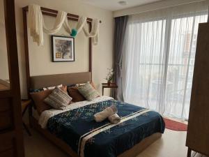 um quarto com uma cama e uma grande janela em Timur Bay by Dream View Studio em Kuantan
