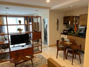 uma cozinha e sala de estar com uma mesa e uma televisão em Timur Bay by Dream View Studio em Kuantan