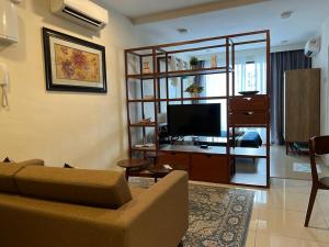 a living room with a couch and a flat screen tv at Timur Bay by Dream View Studio in Kuantan
