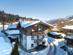 a house with a car parked in the snow at Haus Riedmann Christine in Hopfgarten im Brixental