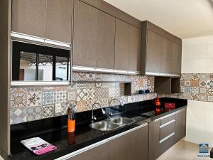 a kitchen with brown cabinets and a sink at Hostel do Lago in Sao Jose do Rio Preto