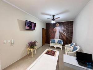 a living room with a painting of a woman on the wall at Hostel do Lago in Sao Jose do Rio Preto