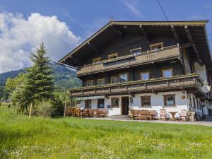 a large wooden house with a table and chairs at Weberhof Top 5 in Brixen im Thale