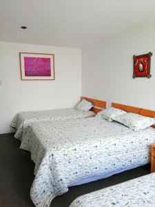 a bedroom with two beds and a picture on the wall at Hotel La Posada Del Ingles in Chiclayo