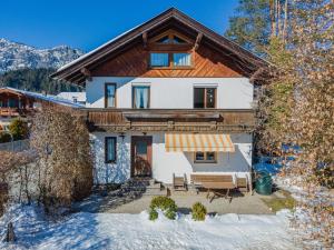 uma casa na neve com um alpendre em Haus Jöchl Top 2 em Sankt Johann in Tirol
