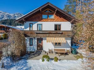 a house in the snow with a porch at Chalet Jöchl in Sankt Johann in Tirol