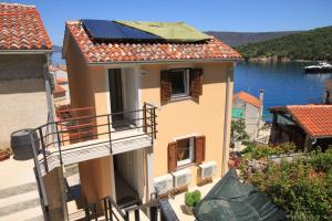 a house with solar panels on top of it at Apartments by the sea Valun, Cres - 8086 in Valun
