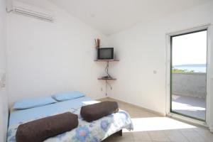 a bedroom with a bed and a tv and a window at Apartments by the sea Banj, Pasman - 8242 in Ždrelac