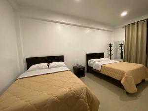 a bedroom with two beds and a window at Santa Lucía Suite Hotel in Chachapoyas
