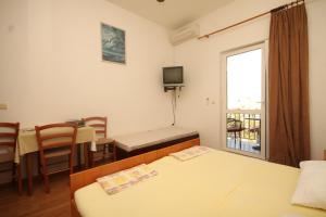 a room with a bed and a table and a window at Studio Cavtat 8576b in Cavtat
