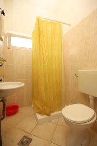 a bathroom with a toilet and a yellow shower curtain at Studio Cavtat 8576b in Cavtat