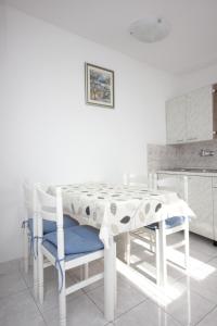 un tavolo bianco e sedie in cucina di Apartments with a parking space Vis - 8448 a Vis