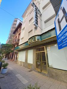 un bâtiment avec un panneau devant lui dans l'établissement Hotel Albamar, à Mar del Plata