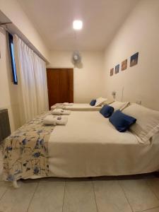 two large beds in a bedroom with blue pillows at Hotel Albamar in Mar del Plata