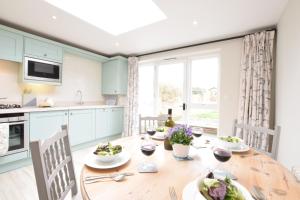 a kitchen and dining room with a wooden table at Sea Thrift Cottage, Aldeburgh in Aldeburgh