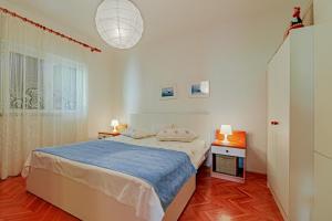 a white bedroom with a bed and a window at Apartments with a parking space Orebic, Peljesac - 10178 in Orebić
