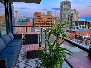 einen Balkon mit einem blauen Sofa und Stadtblick in der Unterkunft LUXURY DT, 2 Bedroom DEAL, Private Balcony, Full Kitchen, Gym - FREE PARKING in Calgary