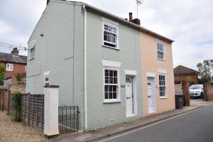 een groen huis aan de kant van een straat bij 1 Tailors Cottage, Woodbridge in Woodbridge