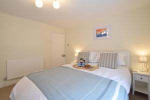 a bedroom with a large bed with a tray on it at 1 Tailors Cottage, Woodbridge in Woodbridge