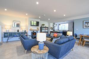 Sea Green Cottage, Walberswick في والبيرسويك: غرفة معيشة بها أريكتان باللون الأزرق وطاولة