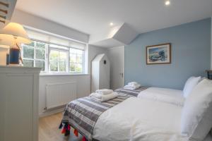 Sea Green Cottage, Walberswick في والبيرسويك: غرفة نوم بها سريرين ونافذة