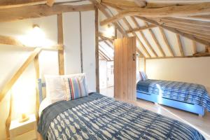 a bedroom with two beds in a room with wooden ceilings at Fishpond House, Sotherton in Sotherton