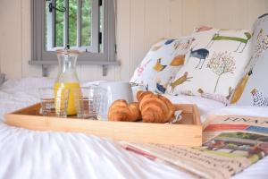 een dienblad met croissants en drankjes op een bed bij Shepherds Pightle, Hollesley in Hollesley