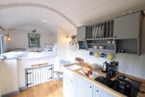 een kamer met een keuken en een slaapkamer met een bed bij Shepherds Pightle, Hollesley in Hollesley