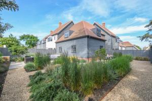 an old house with a garden in front of it at Corner Cottage, Thorpeness in Thorpeness