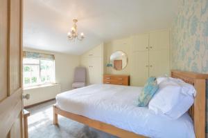 1 dormitorio con cama blanca y ventana en Chapel Cottage, Newbourne en Newbourn