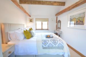 a bedroom with a bed with a tray of food on it at May Barn, Ixworth in Ixworth
