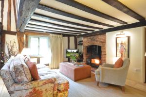 a living room with a couch and a fireplace at Rectory Farm Cottage, Rougham in Rushbrooke
