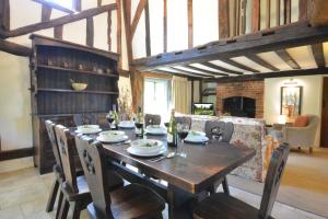 a dining room with a wooden table and chairs at Rectory Farm Cottage, Rougham in Rushbrooke