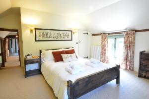 a bedroom with a bed with two towels on it at Rectory Farm Cottage, Rougham in Rushbrooke