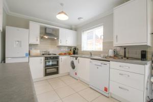 a white kitchen with white cabinets and appliances at Number 51, Halesworth in Halesworth