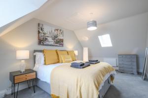 a bedroom with a bed with yellow pillows at Number 51, Halesworth in Halesworth