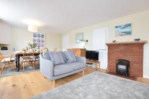 a living room with a couch and a fireplace at Seaflower, Aldeburgh in Aldeburgh