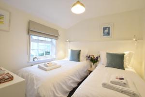 two beds in a small room with a window at Seaflower, Aldeburgh in Aldeburgh