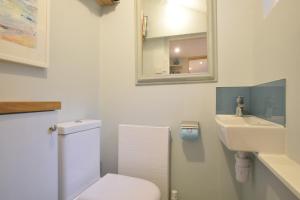 a bathroom with a toilet and a sink and a mirror at Seaflower, Aldeburgh in Aldeburgh