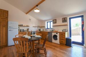 uma cozinha com uma mesa e cadeiras e um frigorífico em Onna's Stable, Sotherton em Sotherton