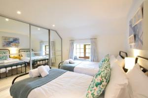 a bedroom with two beds and a mirror at Skelder, Parham in Parham
