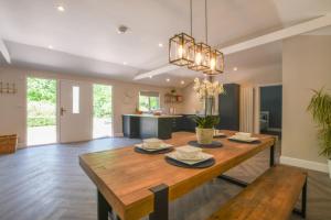 a dining room and living room with a wooden table at The Piglets in Woodbridge