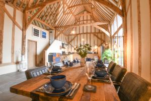 a long wooden table in a large room with chairs at Halcyon Barn, Wissett in Wissett