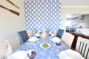un tavolo blu con bicchieri da vino e cibo sopra di St Marys View, Southwold a Southwold