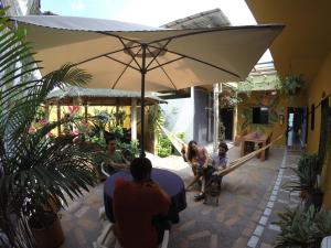 Amagua Hostel في Caracolí: مجموعة أشخاص يجلسون تحت مظلة