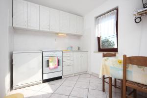 a kitchen with white cabinets and a black and white oven at Studio Punta kriza 383a in Punta Križa