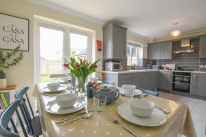 a kitchen with a table with plates and bowls on it at The Sandy House, Leiston in Leiston