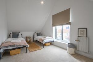 a bedroom with two beds and a window at Salt Marsh House, Southwold in Southwold
